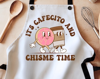 May include: White kitchen apron with a cartoon illustration of a pastry and a cup of coffee. The text reads "It's cafecito and chisme time".