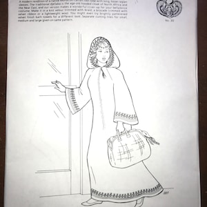 May include: A sewing pattern envelope titled Duriyya's Djellaba by Atira's Fashions No. 30. The front features a black and white line drawing of a hooded robe with long raglan sleeves and decorative trim, accompanied by a large handbag.