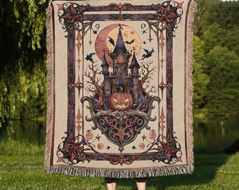 May include: Beige throw blanket with a Halloween-themed design. The illustration features a spooky castle, bats, a full moon, and a jack-o'-lantern. The blanket has a decorative border and fringe. Perfect for adding a touch of spooky decor to any room.