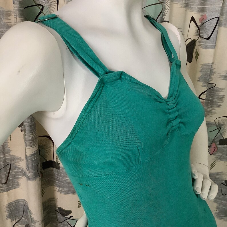 Pu&ograve; includere: Un top senza maniche blu turchese con scollo rotondo e spalline regolabili. Il top presenta un dettaglio arricciato sul seno.