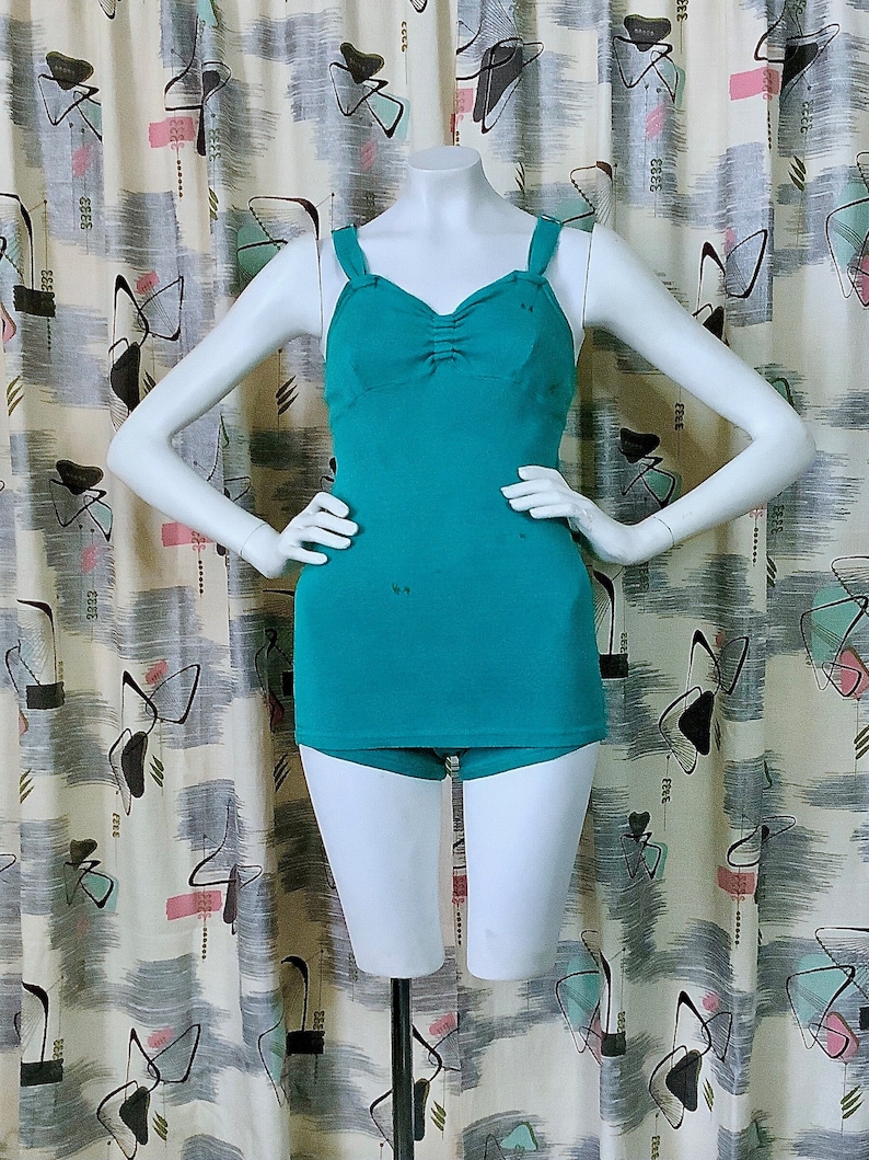 Pu&ograve; includere: Un costume da bagno intero color turchese con scollatura a cuore e un corpetto drappeggiato. Il costume da bagno ha spalline sottili e un fondo a vita alta.