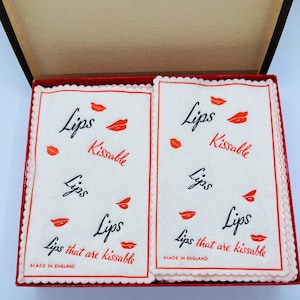 May include: A white ceramic mug with a black handle and the text "But First, Coffee" in a handwritten style. The mug is on a white surface. The mug is approximately 4 inches tall.