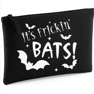 May include: Black zippered pouch with the text "it's Frickin' BATS!" in white. The design includes bat silhouettes and star accents, perfect for Halloween or a spooky theme.