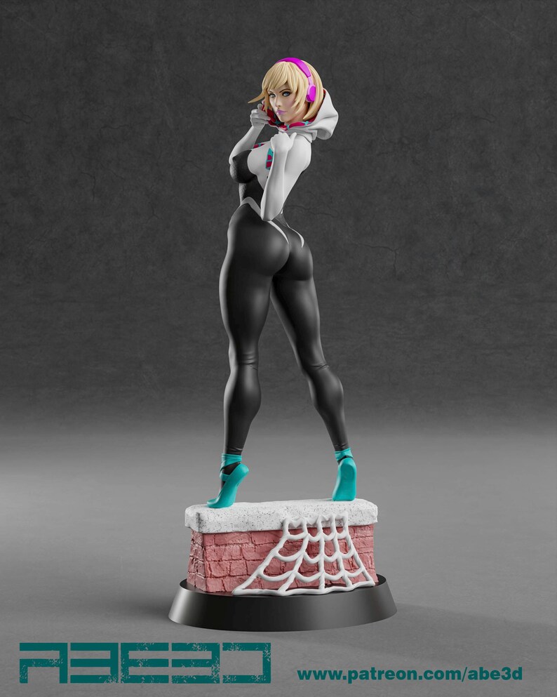 Op de afbeelding: Een 3D-geprinte figuur van een vrouwelijke superheld in een zwart-wit pak, turquoise schoenen en een witte hoodie. De figuur staat op een baksteenachtige basis met een wit spinnenwebontwerp. De figuur heeft blond haar en draagt een roze koptelefoon. De basis heeft de tekst "ABE3D" en "www.patreon.com/abe3d".