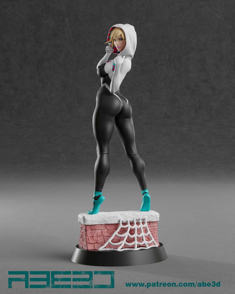 Op de afbeelding: Een 3D-geprinte figuur van een vrouwelijke superheld in een zwart-wit bodysuit met een witte hoodie. De figuur staat op een baksteenachtige basis met een wit spinnenwebontwerp. De figuur draagt ​​blauwe schoenen.