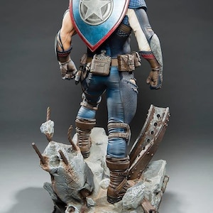May include: A detailed statue of Captain America from the back, showcasing his iconic shield with a white star on a blue background. He wears a blue and white costume with brown boots and a utility belt. The statue is on a detailed base with a distressed, industrial theme.