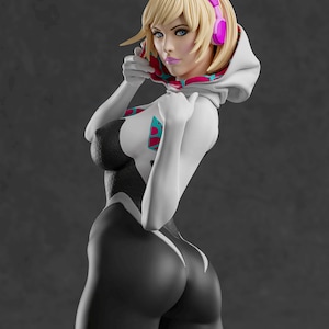 Op de afbeelding: Een 3D-gefigureerde figuur van een vrouw in een wit en zwart bodysuit met een capuchon en roze koptelefoon. De figuur heeft blond haar en poseert tegen een grijze achtergrond. De bodysuit heeft turquoise en roze accenten.