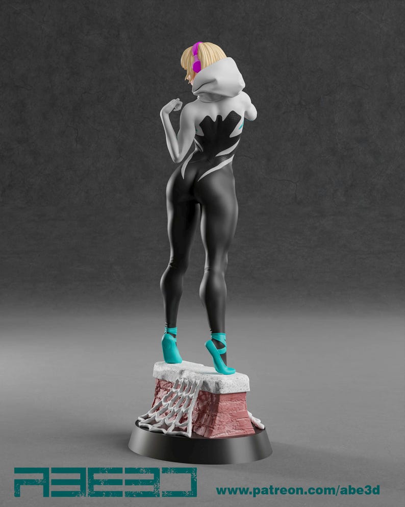 Op de afbeelding: 3D-geprinte figuur van een vrouwelijke superheld in een zwart-wit pak met een spinnenwebontwerp. De figuur heeft blond haar, een witte capuchon en turquoise hakken. De figuur staat op een bakstenen basis.