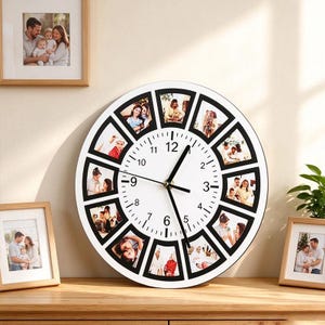 Può includere: Un orologio da parete rotondo con quadrante bianco, numeri neri e lancette nere. Il bordo esterno presenta dodici cornici trapezoidali, ognuna contenente una diversa fotografia di persone, posizionato su una superficie in legno.