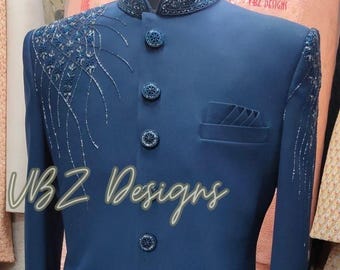 Puede incluir: Chaqueta de traje azul marino con intrincados bordados plateados y azules en los hombros y el cuello. La chaqueta presenta botones decorativos y un bolsillo. El texto "VBZ Designs" se muestra en la parte delantera.