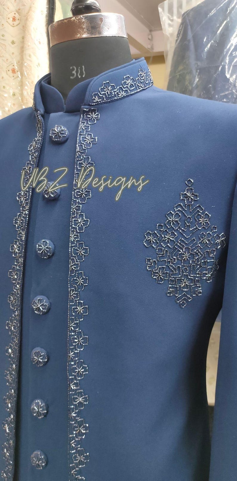 Puede incluir: Chaqueta azul marino con intrincados bordados florales plateados en el cuello, el frente y un dise&ntilde;o en el pecho. La chaqueta presenta botones plateados a juego y el texto "BZ Designs".