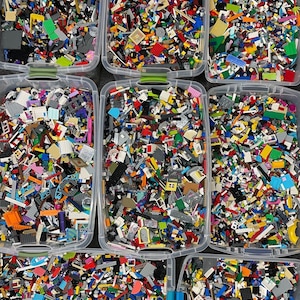 May include: Multiple containers filled with a variety of colorful Lego bricks. The bricks are sorted by color and type.