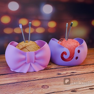 Puede incluir: Dos cuencos de hilo lavanda con hilo y agujas de tejer. Uno tiene forma de lazo, el otro tiene un diseño de espiral. Los cuencos están sobre una superficie de madera con un fondo borroso.