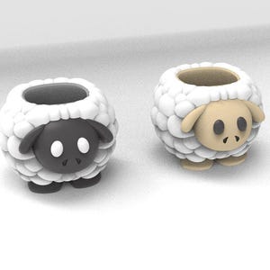 Peut inclure: Deux pots de fleurs en forme de mouton. L'un est noir avec des yeux blancs et un extérieur laineux blanc. L'autre est beige avec un extérieur laineux blanc. Les deux ont une ouverture ronde sur le dessus pour planter.