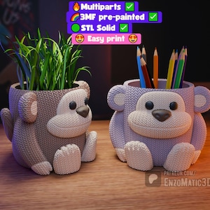 May include: Two monkey-shaped planters, one holding green plants and the other pencils. The planters are in shades of gray and lavender, with white accents. The design includes a textured knit pattern, a dark brown nose, and large ears. The text in the image says "Multiparts", "3MF pre-painted", "STL Solid", and "Easy print".