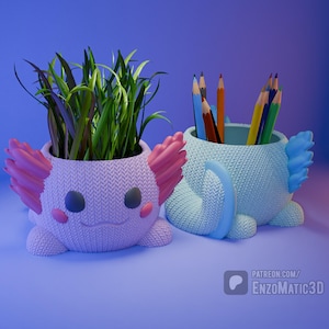 May include: Two axolotl-shaped planters, one holding green plants and the other pencils. The planters are light purple and blue, with pink and blue accents. The axolotls have smiling faces and textured surfaces. The background is a gradient of blue.