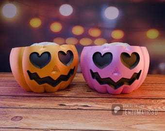 May include: Two Halloween jack-o'-lantern pumpkins with heart-shaped eyes. One pumpkin is orange and the other is pink.