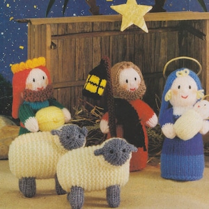 May include: A knitted nativity scene with figures of the Three Wise Men, Mary, Joseph, and baby Jesus, plus two sheep. The figures are in various colours, including red, blue, yellow, and green. A wooden stable and a star complete the scene.