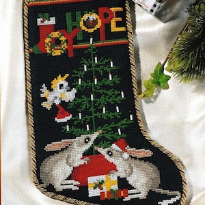 May include: Black Christmas stocking with gold trim, embroidered with a Christmas tree, mice, and the word "HOPE". The stocking also features a small angel wearing a Santa hat and the word "JOY".