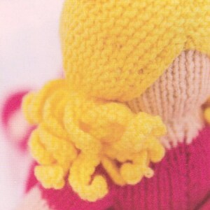 Puede incluir: Primer plano de una mu&ntilde;eca de punto con pelo amarillo y un vestido rosa. El texto "Pull up a running stitch to form the curls into a bunch" es visible. El pelo de la mu&ntilde;eca est&aacute; peinado con rizos.