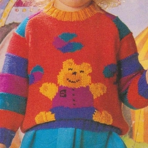 May include: A red, blue, purple, and teal striped sweater with a yellow bear and a blue, purple, and teal design on the front.