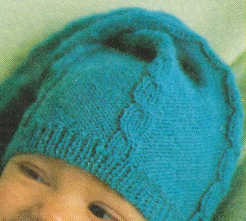 Puede incluir: Un gorro de beb&eacute; de punto azul turquesa con un patr&oacute;n de trenza.