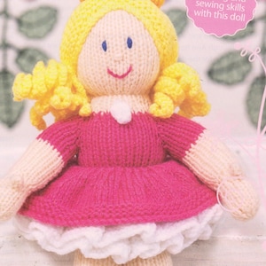 Puede incluir: Mu&ntilde;eca tejida a mano con cabello amarillo, ojos azules y una cara sonriente. La mu&ntilde;eca lleva un vestido rosa con ribete blanco y una corona amarilla. El texto en la imagen dice: "Perfecciona tus habilidades de modelado y costura con esta mu&ntilde;eca."
