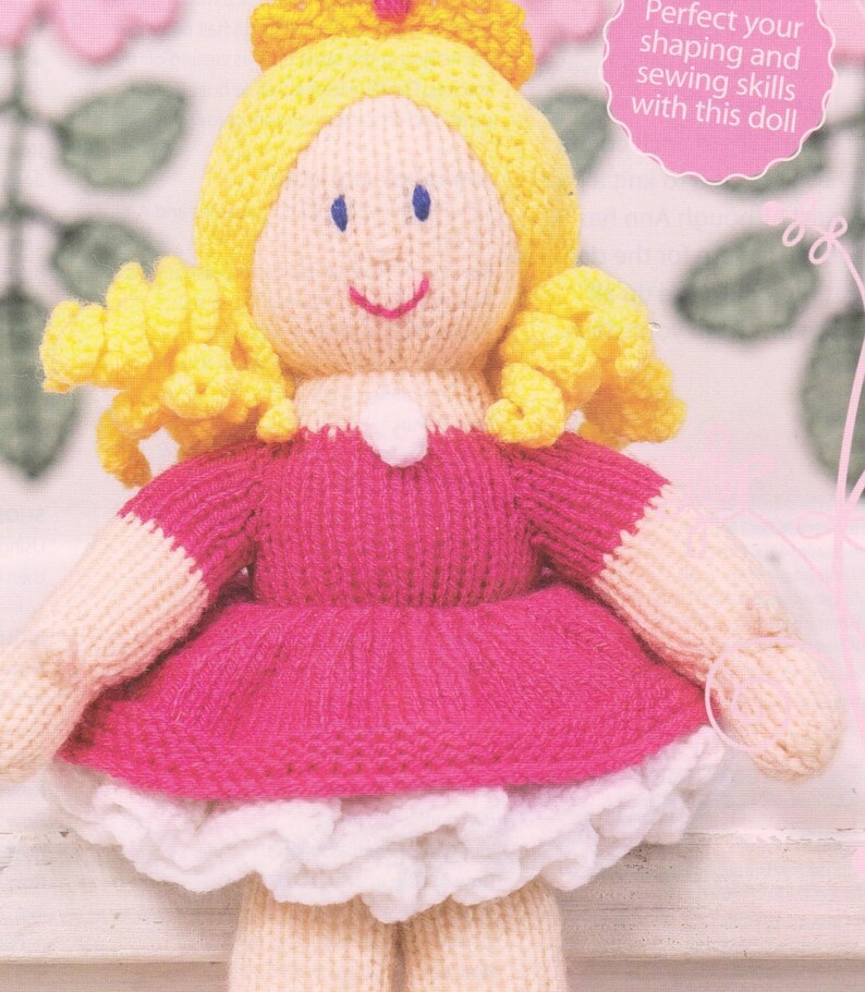 Puede incluir: Mu&ntilde;eca tejida a mano con cabello amarillo, ojos azules y una cara sonriente. La mu&ntilde;eca lleva un vestido rosa con ribete blanco y una corona amarilla. El texto en la imagen dice: "Perfecciona tus habilidades de modelado y costura con esta mu&ntilde;eca."