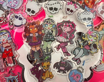 May include: A collection of clear acrylic keychains featuring cartoon characters with a spooky theme. The keychains showcase various characters in vibrant colors, including skulls, monsters, and other creatures. Each keychain has a silver metal ring for attachment.