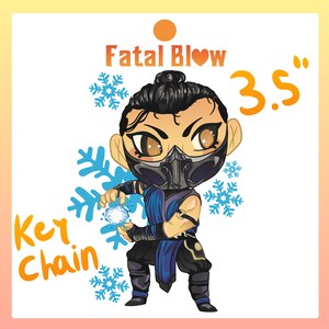 May include: A blue and black chibi-style character with a snowflake design and the text "Fatal Blow" and "Key Chain" in yellow. The character is holding a blue ice ball and has a black mask. The text "3.5" is in yellow and appears to be the size of the keychain in inches.