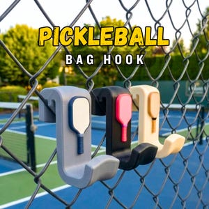 May include: Three pickleball bag hooks in gray, black, and cream colors, each with a paddle design. The hooks are attached to a chain-link fence, with the words "PICKLEBALL BAG HOOK" in yellow and white text.