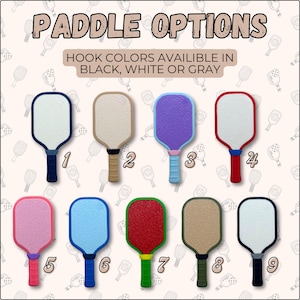 May include: Nine pickleball paddles with different color combinations. The text "PADDLE OPTIONS" is at the top. The text "HOOK COLORS AVAILABLE IN BLACK, WHITE OR GRAY" is below the title. Each paddle has a different colored handle and paddle face.