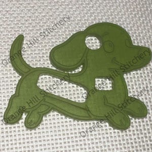 May include: A green plastic dachshund-shaped sewing needle threader. The threader has a hole in the top of the head and a hole in the body.