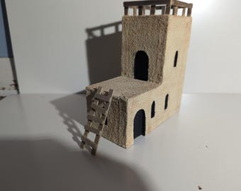 Miniature sandstone building with ladder for tabletop games.