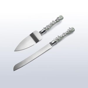 May include: A cake knife and server set. The stainless steel blades are paired with light green handles adorned with clear, sparkling crystal accents. The set is designed for cutting and serving cake.