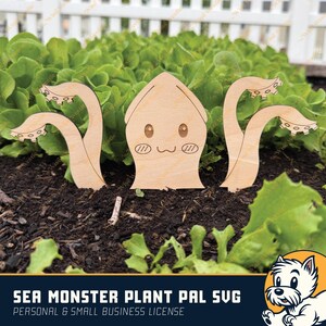 May include: A wooden cutout of a cartoon sea monster with large eyes and a smiling mouth. The monster has eight tentacles, two of which are sticking up out of the ground. The monster is surrounded by green leafy plants.