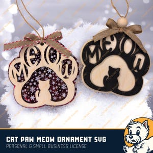 May include: Two wooden cat paw ornaments with the word "MEOW" cut out. One has a red and white snowflake design, the other has a black border. Both have a cat silhouette. They hang from twine with decorative bows.