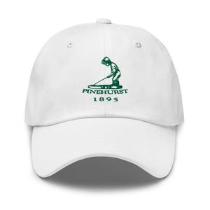 May include: White baseball cap with a green embroidered logo of a golfer swinging a club with the text "Pinehurst 1895".