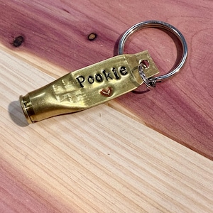 May include: Brass key chain with a heart and the name "Pookie" engraved on it.