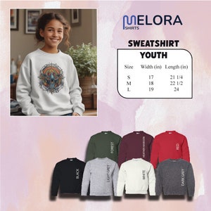 May include: White youth sweatshirt featuring a colourful graphic design. The image includes a size chart with measurements in inches. Additional sweatshirts are displayed in black, light grey, forest green, white, heather maroon, red, and dark grey.