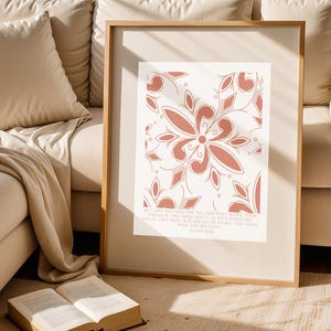 May include: A framed print with a terracotta floral pattern on a cream backdrop. The design includes a central flower and repeating leaf and diamond shapes. The print also features text from Psalm 46:10.