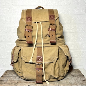 Grote vintage canvas camerarugzak met regenhoes en safari-achtige binnenvoering, kaki kleur.