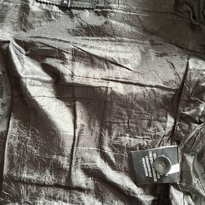 May include: Black leather jacket with a black label that says "Dimitri Collection" and "XL". The jacket has a black button and a label with the text "DESIGNED IN CANADA CONCEPUTA IN CANADA LINING/DOUBLURE 100% POLYESTER"