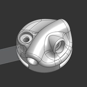 May include: A light grey 3D-rendered object with a rounded, asymmetrical form. It has several circular openings and a curved, tube-like projection. The object's shape is defined by visible lines, hinting at a mechanical or industrial design.