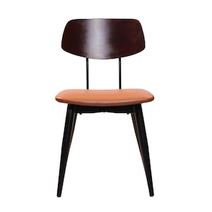 May include: A mid-century modern style chair with a dark brown wooden back and black legs. The seat is a warm tan color. The chair has a minimalist design, suitable for dining or as an accent piece.