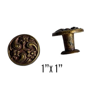 May include: Brass cabinet knob with a floral design. The knob is 1 inch in diameter.