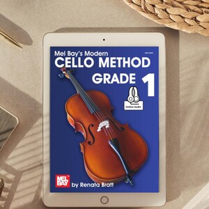 Può includere: Un tablet mostra la copertina di "Mel Bay's Modern Cello Method Grade 1" di Renata Bratt. La copertina presenta un'illustrazione di violoncello su sfondo blu. Il tablet è su una superficie neutra con una penna e un cestino intrecciato.