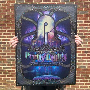 May include: A psychedelic poster for the Pretty Lights music festival. The poster features a purple, blue, and pink color scheme with a large, stylized "P" in the center. The text "Pretty Lights" is written in a colorful, stylized font. The poster also includes the dates "May 31 & June 1, 2024" and the location "Hampton Coliseum, Hampton VA."