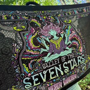 May include: A black fabric tapestry featuring a central illustration of a multi-armed figure in a meditative pose surrounded by colorful swirling patterns. The text reads "VALLEY OF THE SEVEN STARS" and "HEADY THREADY" in a stylized font.