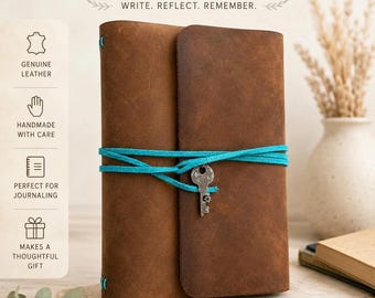 Könnte beinhalten: Ein braunes Lederjournal mit einem umlaufenden türkisfarbenen Wildlederband und einem silberfarbenen Schlüsselanhänger. Der Text lautet HANDMADE LEATHER JOURNAL und WRITE. REFLECT. REMEMBER. Symbole weisen auf echtes Leder hin.